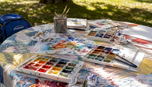 Overhead view of children's painting supplies and table with logo